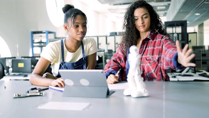 zwei junge Mädchen mit Tablet und Roboter
